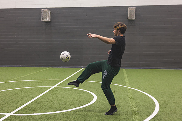 Student kicking a soccer ball in the UWF Pedagogy.