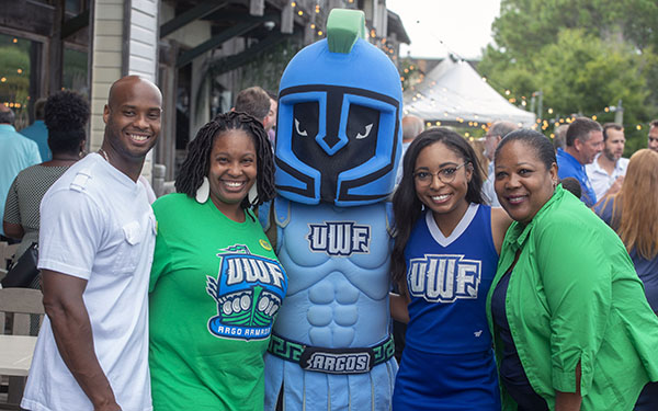Four people pose with Argie