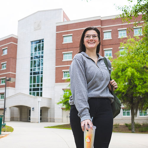 Student standing outside a UWF residence hall