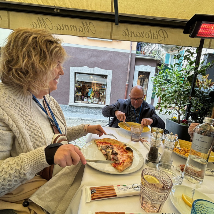 A woman eating pizza at a restaurant in Italy