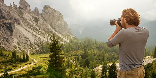 Man taking photographs of mountain landscape