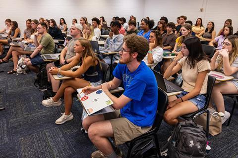 Students looking at a speaker at the front of the classroom