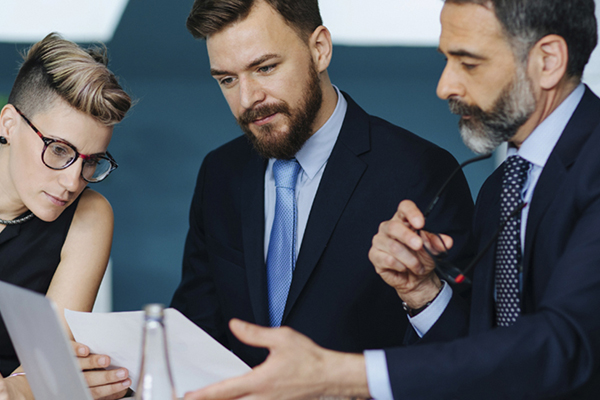 Business professionals looking at a contract at a meeting table.