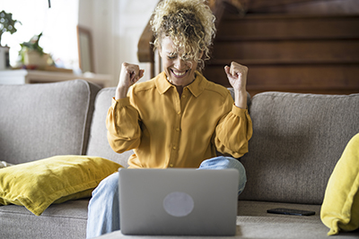 Save Download Preview Happy woman celebrate in and exult in front a laptop computer